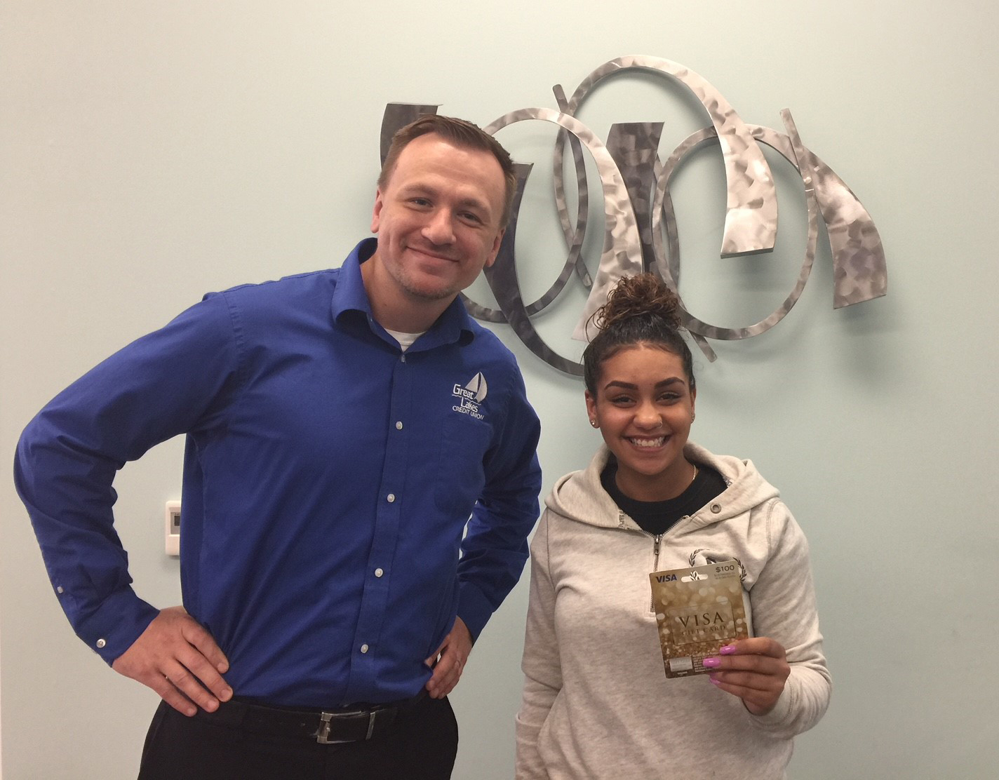 Youth savings month winner holding up her VISA gift card